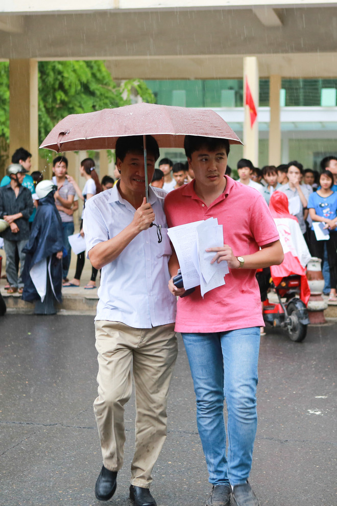 Sinh viên tình nguyện dùng ô to đưa sĩ tử thoát cơn mưa rào ảnh 7