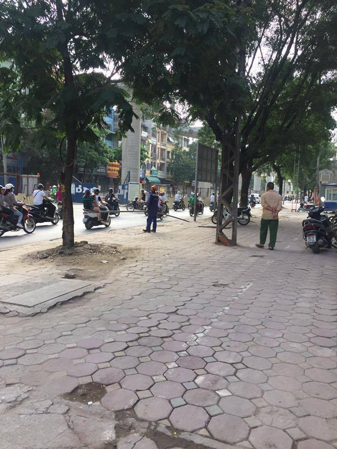Một công nhân đã nhanh chóng 'thu dọn hiện trường' trước sự bàng hoàng của nhiều người đi đường. (Ảnh: PV/Vietnam+) Phát hoảng vì thanh sắt rơi từ công trình đường sắt trên cao xuống phố ảnh 5