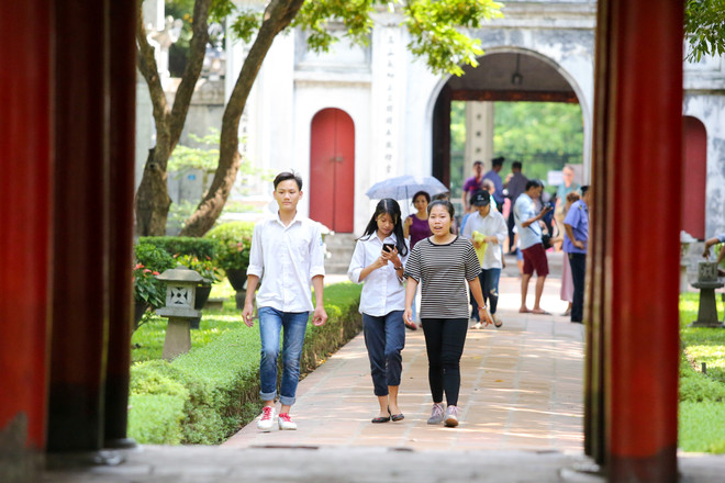 Trời nắng gắt nhưng nhiều phụ huynh và các sĩ tử vẫn đến Văn Miếu - Quốc Tử Giám dâng hương làm lễ, cầu may mắn, thành công cho kỳ thi diễn ra vào sáng mai. (Ảnh: Minh Sơn/Vietnam+) Sĩ tử Hà Nội nô nức đến Văn Miếu cầu may trước ngày thi vào lớp 10 ảnh 3