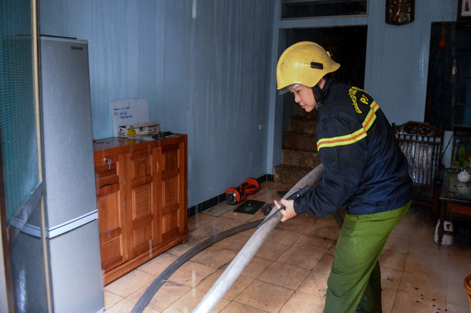 Lực lượng Phòng cháy chữa cháy phải đưa vòi phun nước sang căn nhà bên cạnh. (Ảnh: Minh Sơn/Vietnam+) Hà Nội: "Bà hoả" thiêu rụi 4 căn nhà trên đường Trần Khát Chân ảnh 7