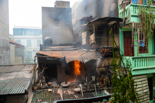 Ngọn lửa thiêu rụi toàn bộ căn nhà ba tầng. (Ảnh: Minh Sơn/Vietnam+) Hà Nội: "Bà hoả" thiêu rụi 4 căn nhà trên đường Trần Khát Chân ảnh 1