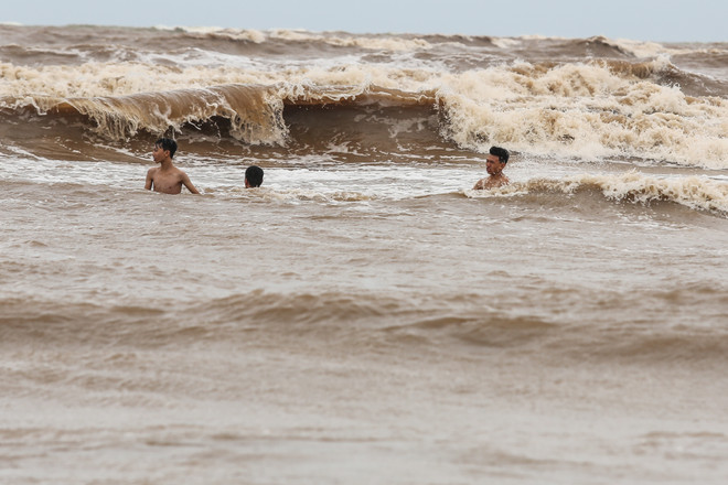 Bất chấp lệnh cấm tắm, du khách đổ xô bơi biển "đón" bão số 2 ảnh 9
