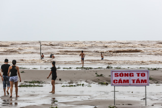Bất chấp lệnh cấm tắm, du khách đổ xô bơi biển "đón" bão số 2 ảnh 1