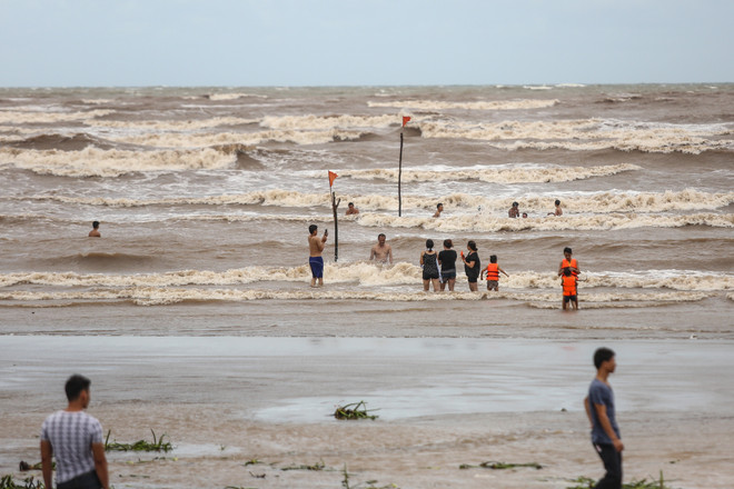 Bất chấp lệnh cấm tắm, du khách đổ xô bơi biển "đón" bão số 2 ảnh 3