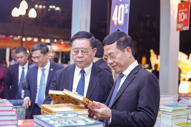 Trưởng Ban Tuyên giáo Trung ương Nguyễn Trọng Nghĩa và Bộ trưởng Bộ Thông tin và Truyền thông tham quan các gian hàng sách. (Ảnh: Diễm Hằng/Vietnam+) vnp_ngay sach va van hoa doc.jpg