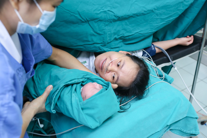 Lặng người trong giây phút người mẹ lần đầu nhìn thấy con mình. Còn gì xúc động hơn khoảnh khắc mẹ và bé lần đầu da kề da. (Ảnh: Minh Sơn/Vietnam+) Lặng người trước hình ảnh vượt cạn đầy cảm xúc của bà mẹ Việt ảnh 12