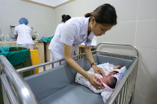 Trẻ sơ sinh sẽ được các nữ điều dưỡng mang đi tắm và vệ sinh. Khoảng 4 - 6 tiếng sau ca mổ đẻ, các bé sẽ được trở lại với vòng tay người mẹ. (Ảnh: Minh Sơn/Vietnam+) Lặng người trước hình ảnh vượt cạn đầy cảm xúc của bà mẹ Việt ảnh 14