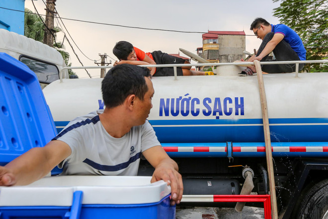 Người dân Thủ đô đang lấy nước miễn phí tại Nhà máynước Hạ Đình. (Ảnh: Minh Sơn/Vietnam+) Chi tiết các điểm cấp nước sạch miễn phí tại Hà Nội sau sự cố sông Đà ảnh 1