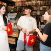 Du khách Mỹ được tặng cờ đỏ sao vàng khi du lịch Thành phố Hồ Chí Minh cuối tháng Tư vừa qua. (Ảnh minh họa: CTV/Vietnam+)