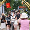 Các gia đình lưu lại khoảnh khắc tại Làng Văn hóa Du lịch các Dân tộc Việt Nam. (Ảnh: Khánh Hòa/TTXVN)