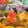 Hoa hậu Thùy Tiên và "anh trai" Quang Trung trải nghiệm bán hoa Tết bên bến sông Sài Gòn. (Ảnh: CTV/Vietnam+)