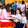 Chủ tịch Miss World, bà Julia Morley trao quà cho trẻ em và phụ nữ khó khăn Việt Nam. (Ảnh: CTV/Vietnam+)