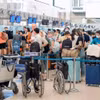 Hành khách làm thủ tục đi máy bay tại Cảng Hàng không quốc tế Nội Bài. (Ảnh: PV/Vietnam+)
