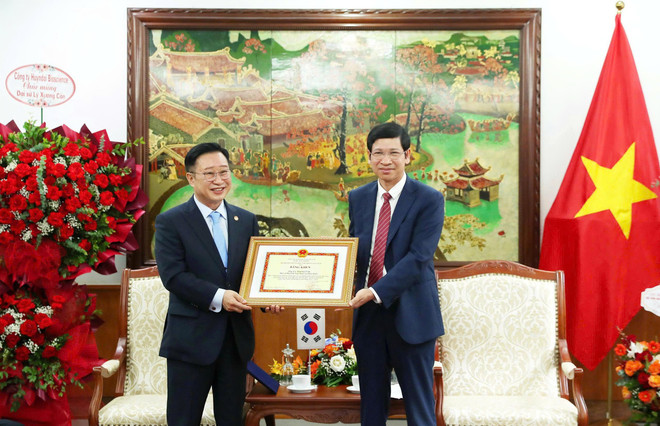 Deputy Minister Ho An Phong presented the Certificate of Merit from the Minister of Culture, Sports and Tourism to Vietnam's Tourism Ambassador to Korea, Mr. Ly Xuong Can, in recognition of his contributions. (Photo: CTV/Vietnam+) z6840107182974-d17e5a563dd8bf4dde595b052d7f9bd1.jpg