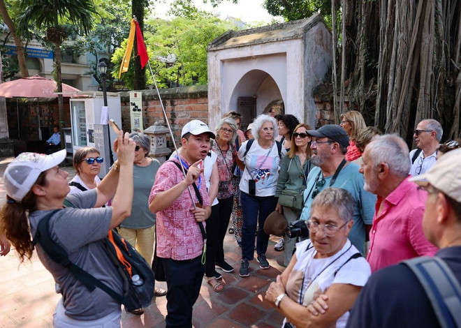 Internationella turister besöker Litteraturtemplet. (Foto: Thanh Tung/VNA) vna-potal-du-lich-viet-nam-sap-can-dich-7746272.jpg