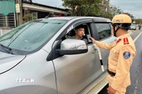 Lực lượng cảnh sát giao thông đo nồng độ cồn người tham gia giao thông trong những ngày nghỉ Tết. (Ảnh: Công Tường/TTXVN)