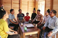 Bí thư Chi bộ Lý Văn Chém (áo sọc) rất được bà con người Cống ở bản Táng Ngá tín nhiệm. (Ảnh: Nguyễn Oanh/TTXVN)