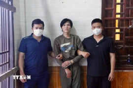 Lực lượng chức năng bắt đối tượng Trần Văn Huy. (Ảnh: TTXVN phát)