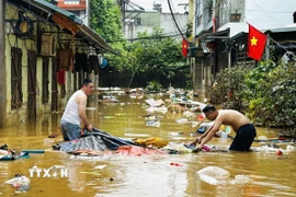 Người dân dọn dẹp nhà cửa sau trận lụt ở phường Hà Giang 1 (Tuyên Quang). (Ảnh: Đức Thọ/TTXVN)
