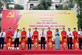 Các đại biểu thực hiện nghi thức cắt băng khai mạc Triển lãm. (Ảnh: Thu Hương/TTXVN)