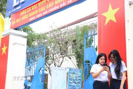 Cử tri đủ tròn 18 tuổi học tại Trường THPT Lý Tự Trọng, phường Nha Trang, tỉnh Khánh Hòa tìm hiểu thông tin về các ứng cử viên trên không gian số. (Ảnh: Phan Sáu/TTXVN)