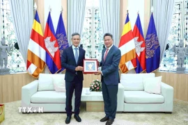 Đại sứ Việt Nam tại Campuchia Nguyễn Minh Vũ (bên trái) trao tặng phẩm lưu niệm cho Phó Thủ tướng kiêm Phó Chủ tịch thứ nhất CDC Sun Chanthol. (Ảnh: TTXVN phát)