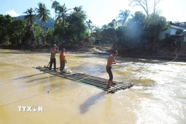 Khu vực giữa suối, dòng chảy mạnh và mực nước sâu nhưng người dân không hề có áo phao, thiết bị cứu sinh khi qua suối bằng bè mảng. (Ảnh: Xuân Tiến/TTXVN)