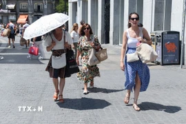 Người dân di chuyển dưới trời nắng gay gắt tại Madrid, Tây Ban Nha. (Ảnh: THX/TTXVN)