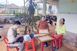 Hỗ trợ bà con đồng bào dân tộc thiểu số thực hiện các thủ tục hành chính ngay tại nhà. (Ảnh: Hưng Thịnh/Vietnam+)