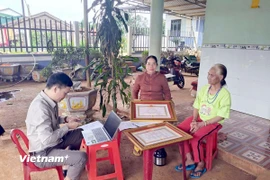 Hỗ trợ bà con đồng bào dân tộc thiểu số thực hiện các thủ tục hành chính ngay tại nhà. (Ảnh: Hưng Thịnh/Vietnam+)