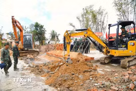 Lực lượng quân đội cùng nhiều phương tiện, máy móc được huy động hỗ trợ người dân xây nhà mới. (Ảnh: Tường Quân/TTXVN)