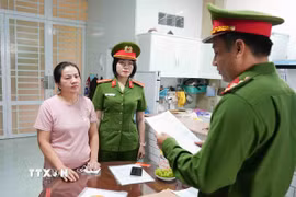 Cơ quan điều tra tống đạt các quyết định đối với Nguyễn Thị Mẫn. (Ảnh: TTXVN phát)