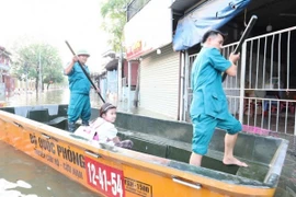Lực lượng cứu hộ của xã Tiến Thắng đưa học sinh vượt mưa lũ đến trường. (Nguồn: Báo Hà Nội mới)