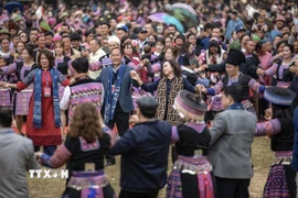 Các đại biểu và du khách cùng tham gia phần hội, nắm tay nhau nhảy quanh cây nêu theo điệu khèn Mông. (Ảnh: Trọng Đạt/TTXVN)
