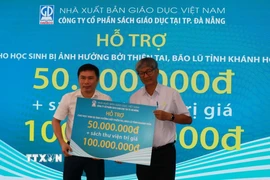Nhà xuất bản Giáo dục Việt Nam trao tặng sách cho học sinh vùng lũ tại Khánh Hòa. (Ảnh Phan Sáu/TTXVN)