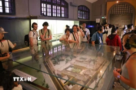 Du khách sử dụng bộ đàm thuyết minh tự động khi tham quan di tích Nhà tù Hỏa Lò, Hà Nội. (Ảnh: Thanh Tùng/TTXVN)