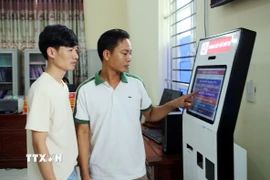 Người dân xã Yên Mô lấy số thứ tự giải quyết thủ tục hành chính. (Ảnh: Nguyễn Lành/TTXVN)