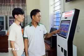 Người dân xã Yên Mô lấy số thứ tự giải quyết thủ tục hành chính. (Ảnh: Nguyễn Lành/TTXVN)