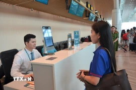 Hành khách thực hiện sinh trắc học nhận diện khuôn mặt trong quá trình làm thủ tục. (Ảnh: Linh Sơn/TTXVN)