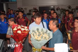Ban lãnh đạo đội tuyển nhận hoa chúc mừng của các cổ động viên. (Ảnh: Trung Tuyến/TTXVN)