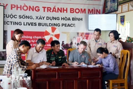 Các bên ký bàn giao và tiếp nhận diện tích đất sạch bom mìn tại xã Hoàn Lão (Quảng Trị). (Ảnh: Tá Chuyên/TTXVN)