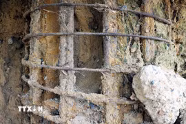 Trụ T3 của cầu Sông Lô bị hư hỏng, lộ nguyên phần bêtông, cốt thép dưới chân cầu. (Ảnh: Tạ Toàn/TTXVN)