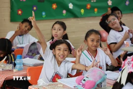 Học sinh lớp 5 mặc áo đồng phục in lá cờ Việt Nam. (Ảnh: Phi Hùng/TTXVN)