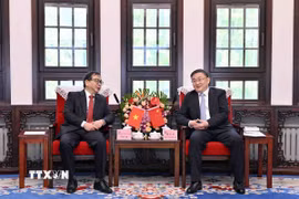 Phó Tổng Giám đốc TTXVN Nguyễn Tuấn Hùng (trái) hội đàm với đồng chí Nhậm Vệ Đông, Ủy viên Ban Cán sự Đảng, Phó Tổng Biên tập Tân Hoa xã. (Ảnh: THX/TTXVN phát)