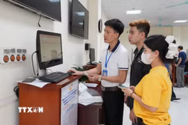 Cán bộ Trung tâm Phục vụ hành chính công phường Vĩnh Yên hướng dẫn người dân làm thủ tục đăng ký kết hôn trên cổng dịch vụ công trực tuyến. (Ảnh: Nguyễn Thảo/TTXVN)