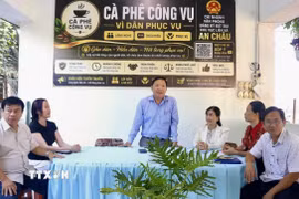 Lãnh đạo Văn phòng Đăng ký đất đai Chi nhánh khu vực liên xã An Châu hướng dẫn người dân hoàn thiện các thủ tục, hồ sơ liên quan đến đất đai tại chương trình. (Ảnh: Thanh Sang/TTXVN)