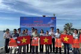 Hải đoàn 32 - Bộ Tư lệnh Vùng Cảnh sát biển 3 tặng quà và cờ Tổ quốc cho ngư dân xã Cà Ná. (Ảnh: TTXVN phát)