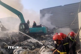 Sau nhiều giờ chiến đấu với "giặc lửa" đám cháy đã được khống chế không để cháy lan sang nhà xưởng liền kề. (Ảnh: Hoàng Hùng/TTXVN)