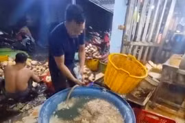Nhân viên cơ sở sơ chế hoa chuối thực hành lại quá trình pha hóa chất vào nước ngâm hoa chuối. (Ảnh: Công an cung cấp)