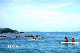 Du khách trải nghiệm chèo sup và lặn mò hải sản ở ven quần đảo Hải Tặc. (Ảnh: Văn Sĩ/TTXVN)